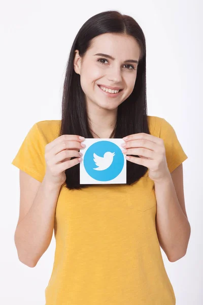 KIEV, UKRAINE - AUGUST 22, 2016: Woman hands holding Twitter logotype icoi bird printed paper. Twitter is an online social networking service that enables users to send and read short messages. — Stock Photo, Image