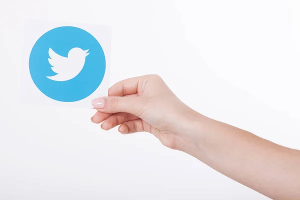 KIEV, UCRANIA - 22 de agosto de 2016: Manos de mujer sosteniendo el logotipo de Twitter papel impreso para pájaros icoi. Twitter es un servicio de redes sociales en línea que permite a los usuarios enviar y leer mensajes cortos . — Foto de Stock