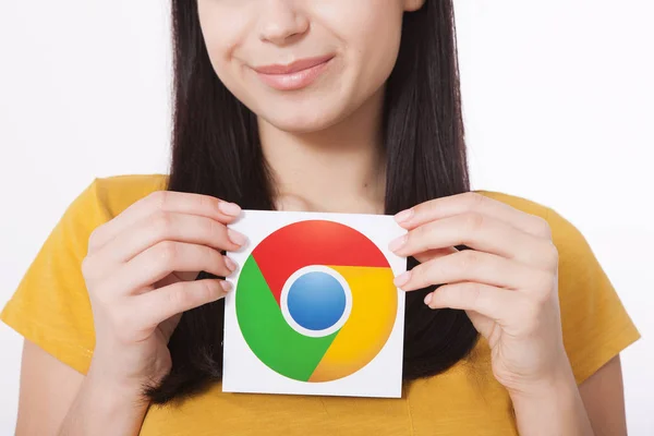 Kiev, Ucrania - 22 de agosto de 2016: Las manos de la mujer sosteniendo el icono de Google Chrome impreso en papel sobre fondo gris. . — Foto de Stock