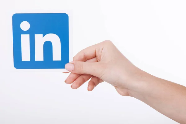Kiev, Ukrajna - 2016. augusztus 22.: Nő kezében tartja Linkedin ikon jele papírra fehér háttér. LinkedIn az üzleti social networking szolgáltatás. — Stock Fotó