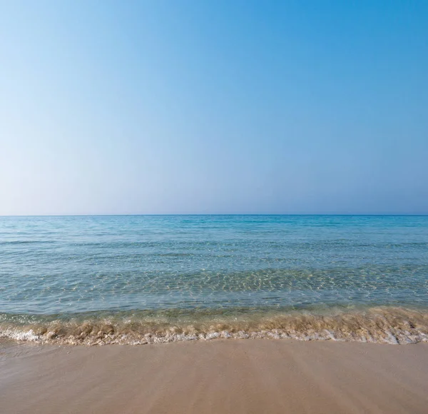 Weiche Welle des blauen Ozeans am Sandstrand. Tropenstrand. Sommer-Hintergrund. Selektiver Fokus. — Stockfoto