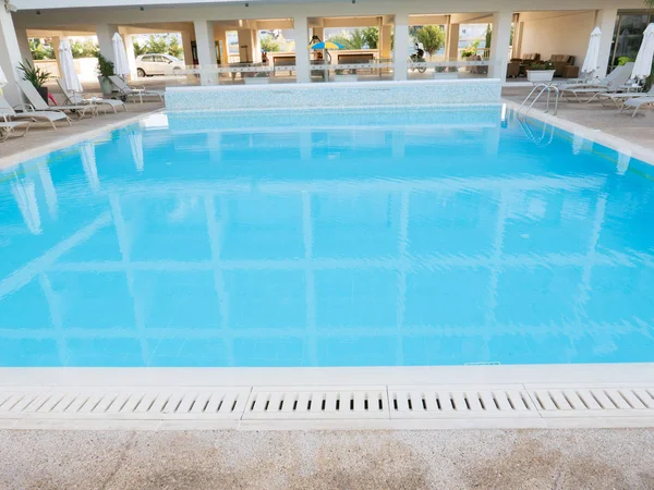 Piscina con scala e acqua limpida in hotel. Interno vuoto con piscina per sfondo. Sfondo estivo, layout per il design . — Foto Stock