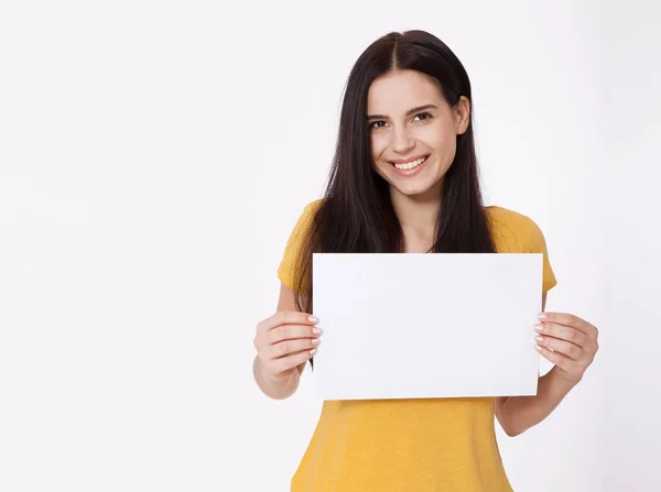 A tua mensagem aqui. Uma jovem bonita com uma tábua vazia. Retrato de estúdio sobre fundo branco. Mockup para design — Fotografia de Stock