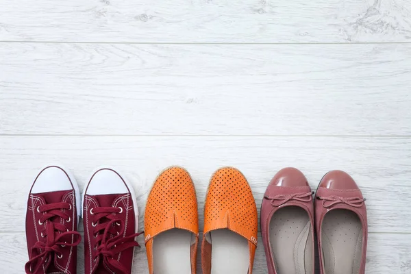 Flat lay fashion set: sapatos de chinelos coloridos em fundo de madeira branca. Vista superior . — Fotografia de Stock