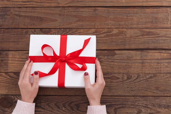 Mujer sosteniendo regalos caja de regalo colocada sobre fondo de mesa de madera —  Fotos de Stock