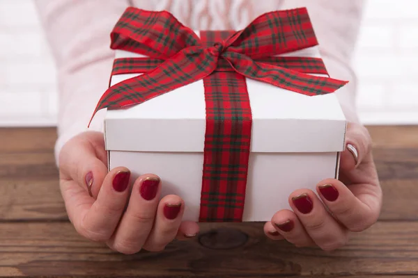 Donna che tiene regali scatola regalo posato su sfondo tavolo di legno — Foto Stock