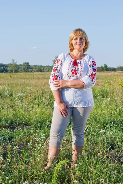 Happy woman with flower relaxes in the grass with a flower. — Stock Photo, Image