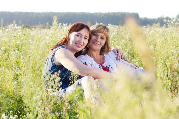 Happy women talking and laughing in nature with a green background — Stock Photo, Image