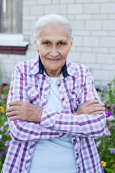 Portret uśmiechający się starszą kobietę. Zdjęcie na tle hause — Zdjęcie stockowe