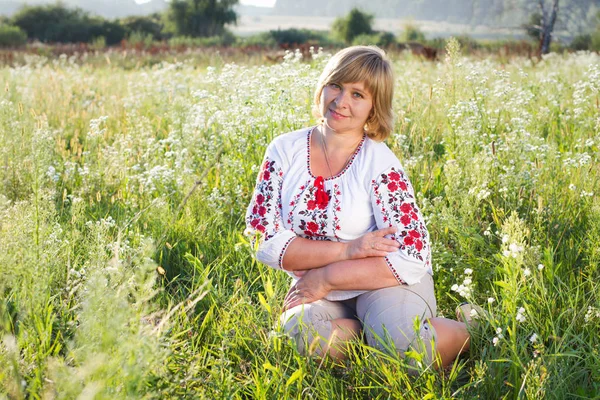 Happy woman with flower relaxes in the grass with a flower. — Stock Photo, Image