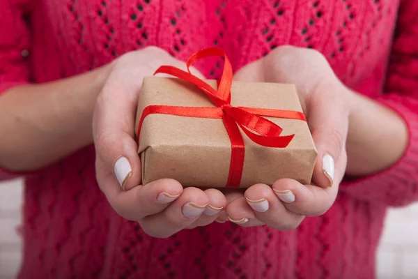 Mani femminili che tengono piccola scatola regalo con nastro . — Foto Stock