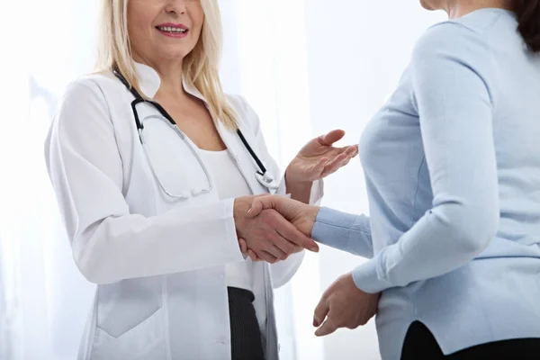 Zdravotní péče a zdravotnické koncepce - lékař s pacientem v nemocnici. Handshake. — Stock fotografie
