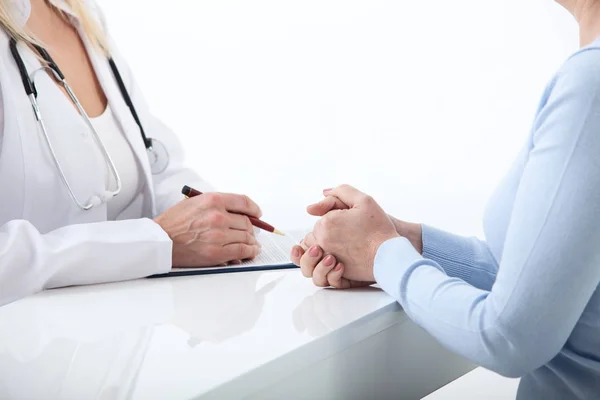 Lékař a pacient se diskutovat něco, jen ruce u stolu zblízka — Stock fotografie