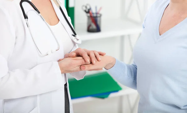 Die Hand des Arztes beruhigt ihre Patientin. Medizinethik und Vertrauenskonzept. Händedruck, Hände in Nahaufnahme — Stockfoto