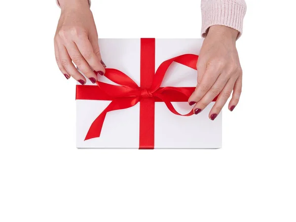 Gift box isolated on white background. Woman holding presents and tying a red ribbon on a gift box — Stock Photo, Image