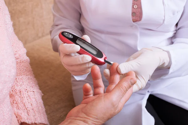 Nurse takes test for sugar in blood of elderly woman at home. — Stock Photo, Image