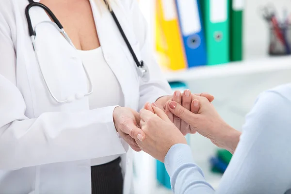 Ruka lékaře uklidnit její pacientka. Lékařská etika a důvěry koncept. Handshake, ruce closeup — Stock fotografie