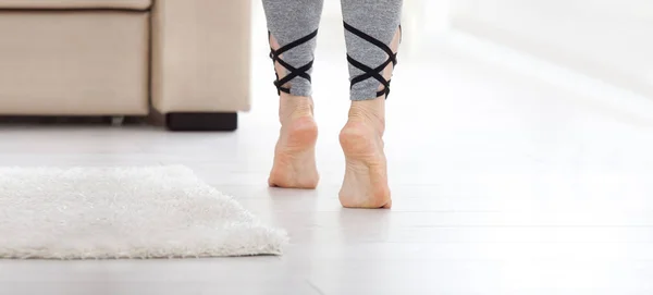 Koncepcja ciepłej podłogi. Zbliżenie kobiece nogi przechodzenie przez drewnianą podłogę w domu — Zdjęcie stockowe