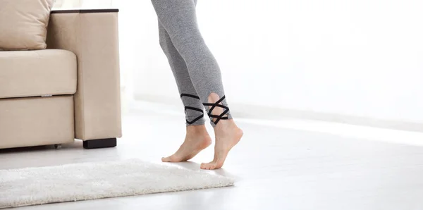 Warm floor concept. Closeup of female legs stepping by hardwood floor at home — Stock Photo, Image