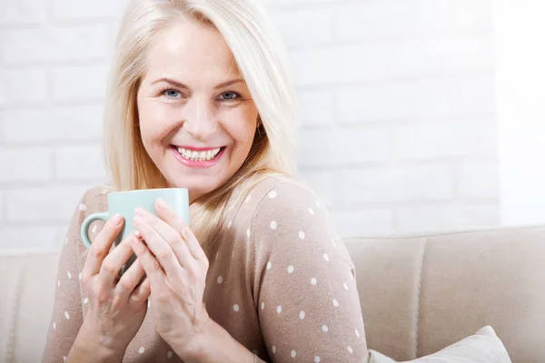 Portrait of happy blonde with mug in hands — Stock Photo, Image
