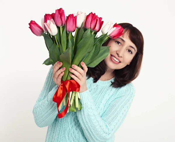 Boldog nő gyönyörű csokor tulipán, kezében a fehér háttér. — Stock Fotó