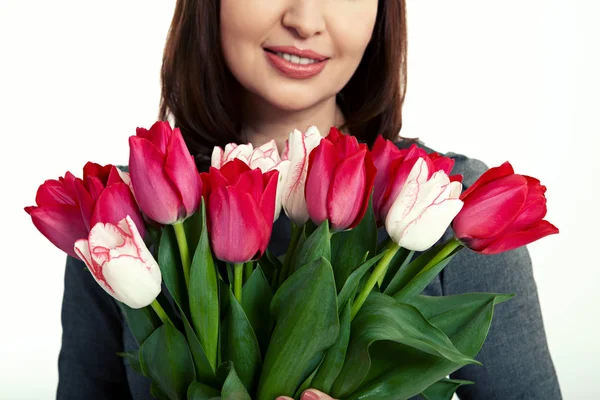 Felice bella donna con bouquet di tulipani in mano su sfondo bianco . — Foto Stock