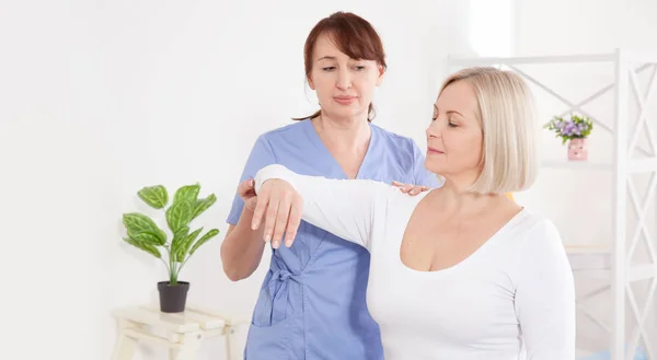 Physiotherapeut arbeitet mit Patienten mittleren Alters in Klinik — Stockfoto