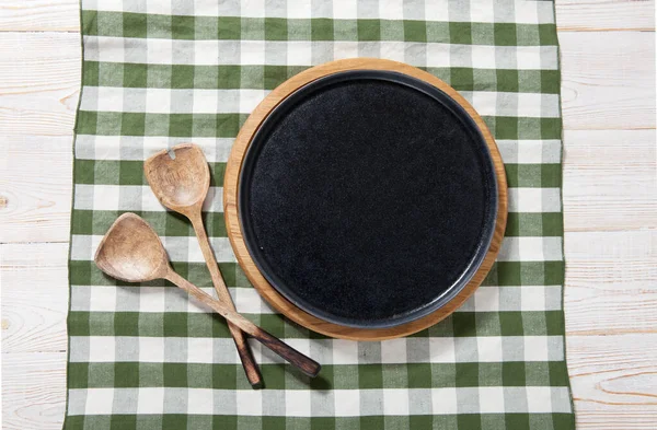 Černá deska nebo podnos nebo Pizza deska s ubrus na dřevěném stole. Pohled shora — Stock fotografie