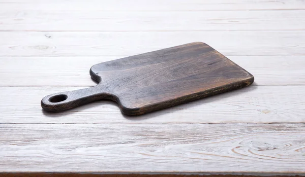 Cutting board on the wooden background. Top view. — Stock Photo, Image