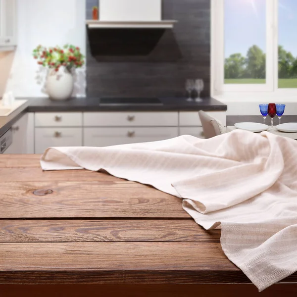 Mesa de madeira vazia com toalha de mesa perto da janela na cozinha. Guardanapo perto vista superior zombar. Cozinha rústico fundo . — Fotografia de Stock