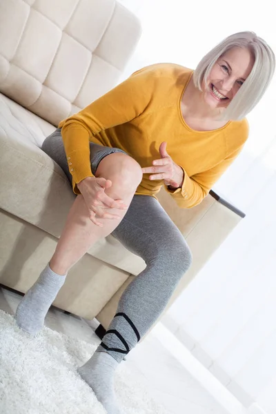 Donna di mezza età che soffre di dolore alle gambe a casa, primo piano. Concetto di lesione fisica . — Foto Stock