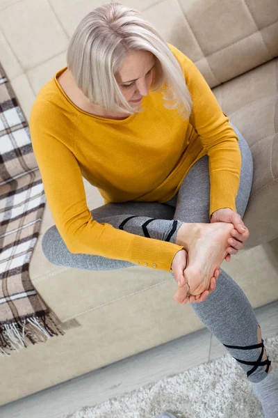 Középkorú nő, aki lábfájástól szenved otthon, közelről. Fizikai kár fogalma. — Stock Fotó