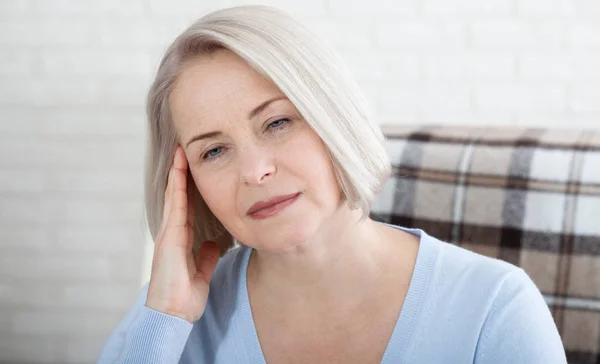 Kobieta cierpiąca na stres lub ból głowy grymaszący w bólu, gdy trzyma plecy szyi drugą ręką do skroni, z przestrzenią do kopiowania. Koncepcja zdjęcia ze wskazaniem miejsca bólu. — Zdjęcie stockowe