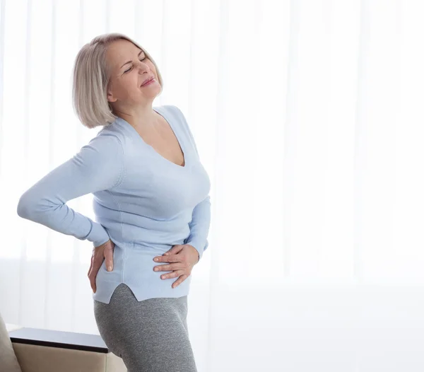 Frau mit Schmerzen hält ihren Bauch auf der rechten Seite — Stockfoto