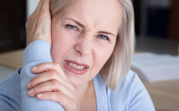 Tinnitus. Nahaufnahme Seitenprofil kranke Frau mit Ohrenschmerzen, die ihren schmerzenden Kopf berühren. — Stockfoto