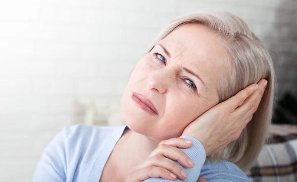 Tinnitus. Closeup up side profile sick female having ear pain touching her painful head. — Stockfoto