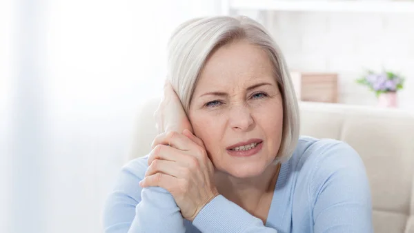 Tinnitus. Primer plano perfil lateral mujer enferma teniendo dolor de oído tocando su dolorosa cabeza . —  Fotos de Stock