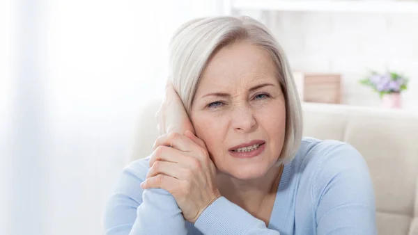 Tinnitus. Closeup up side profile sick female having ear pain touching her painful head. — ストック写真