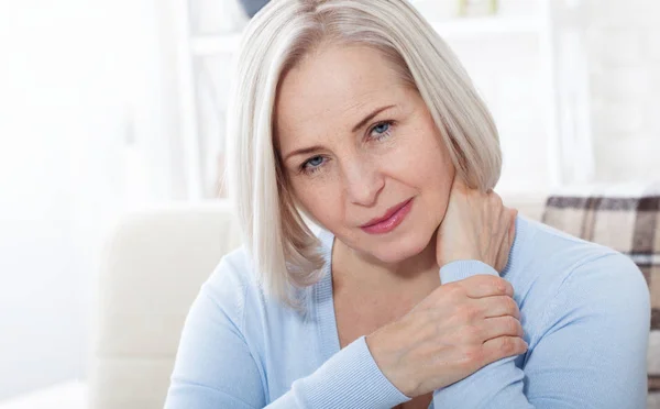 Woman with pain in her neck, medical shot at home. Concept photo with indicating location of the pain. — Stockfoto