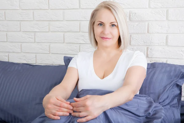 Mujer se sienta en la cama después de dormir en la cama en casa — Foto de Stock