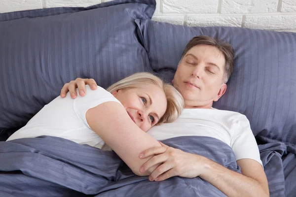Spokojna para spanie i spooning na łóżku w sypialni w domu. — Zdjęcie stockowe