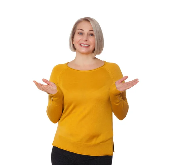 Middle aged blonde emotionally posing in a studio. Happy woman in yellow bright sweater on white background — Stock Photo, Image