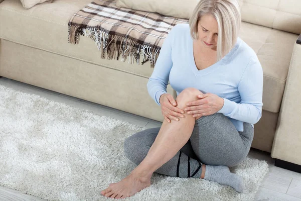 Μεσήλικη γυναίκα που υποφέρει από πόνο στο πόδι στο σπίτι, κοντινό πλάνο. Έννοια σωματικής βλάβης. — Φωτογραφία Αρχείου