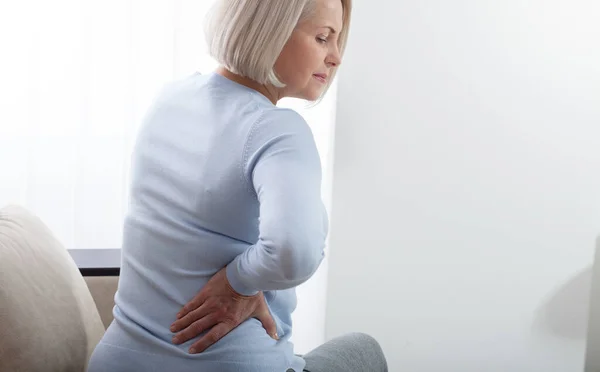 Frau mit Schmerzen hält ihren Bauch auf der rechten Seite — Stockfoto