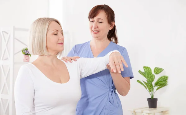 Fysiotherapeut werkt met patiënten van middelbare leeftijd in de kliniek — Stockfoto