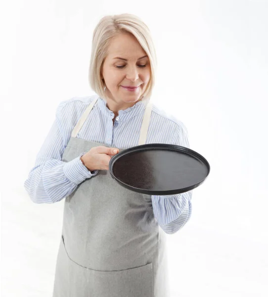 Mulher da cozinha dá placa preta vazia para seus produtos publicitários isolados no fundo branco. Preparar para utilização — Fotografia de Stock