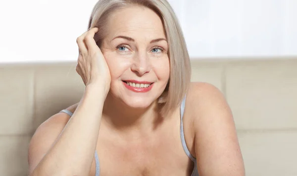 Vacker medelålders blond kvinna visar upp sin perfekt välvårdade ansikte. Kollageninjektioner vid plastikkirurgi. Makro ansikte. Selektivt fokus på ansiktet. Realistiska bilder med sina egna brister. — Stockfoto