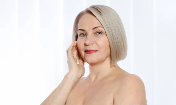 Portrait of cheerful senior woman smiling while looking away at spa. Happy mature woman after spa massage and anti-aging treatment on face. Realistic images with their own imperfections. — Stock Photo, Image