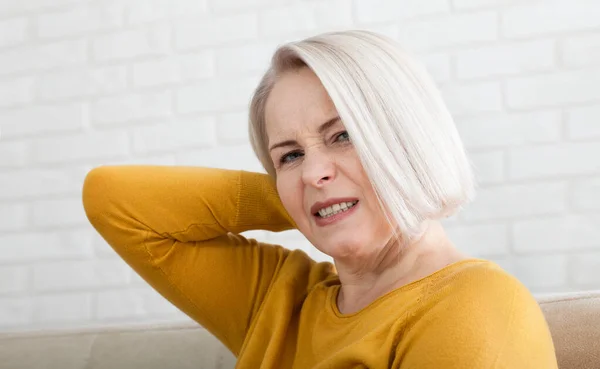 Woman with pain in her neck, medical shot at home. Concept photo with indicating location of the pain. — Stock Photo, Image