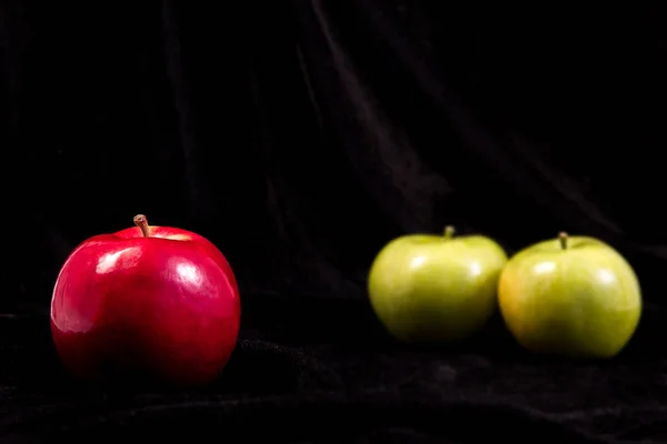 three apples on a black background